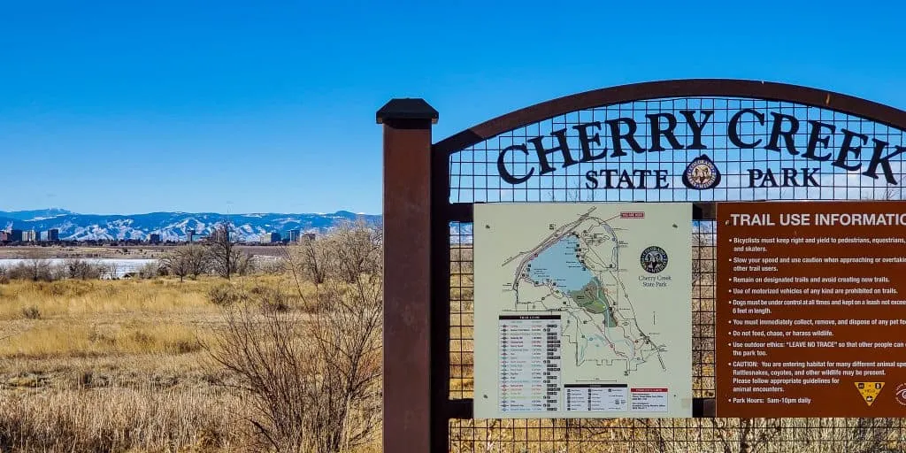Cherry Creek State Park sign with Rocky Mountains in the background