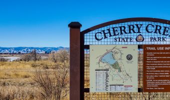 Cherry Creek State Park sign with Rocky Mountains in the background