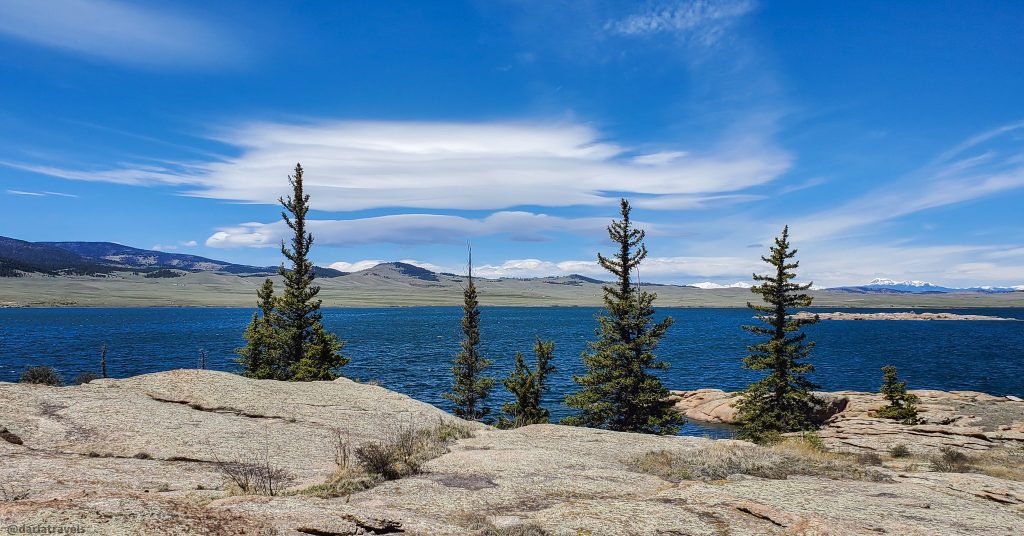 View of Eleven Mile Reservoir in Eleven Mile State Park, near Woodland Park, Colorado. Rocky shore with sparse evergreens in the foreground