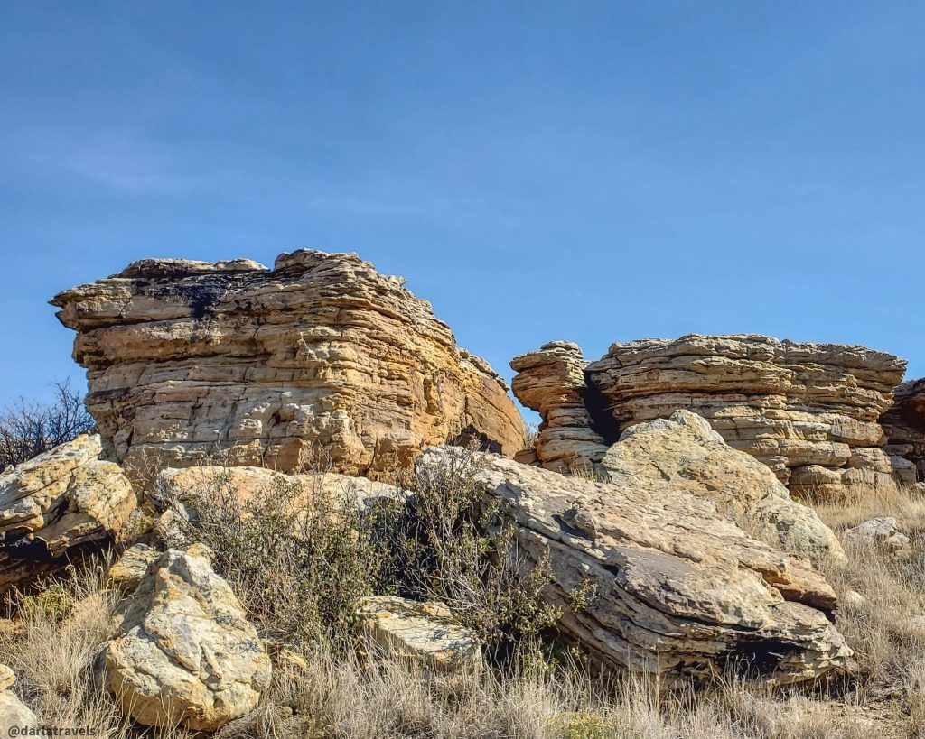 Layered Dakota  sandstone rock formations against a clear blue sky.