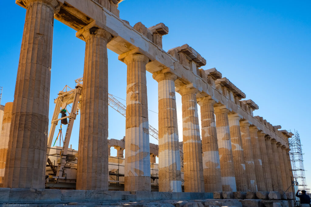 Close-up of the Doric columns of the Parthenon in Athens, with scaffolding and construction equipment visible. Tour on your own in Athens Greece