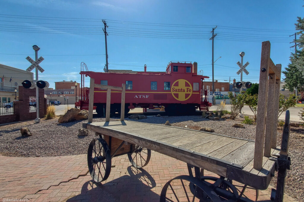 Vintage Santa Fe caboose and rail cart in La Junta’s rail-themed roadside park. Santa Fe Plaza