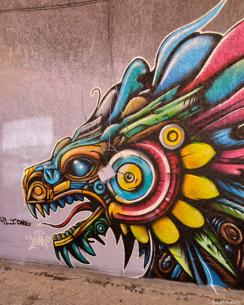 Colorful robotic dragon mural on textured wall in downtown La Junta, Colorado.