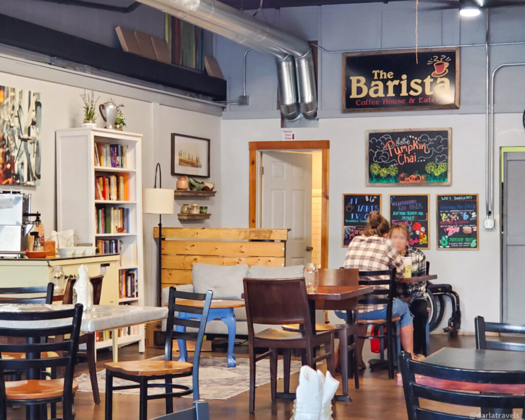 Inviting interior of The Barista Coffee House in La Junta, Colorado with books and chalkboard menus.