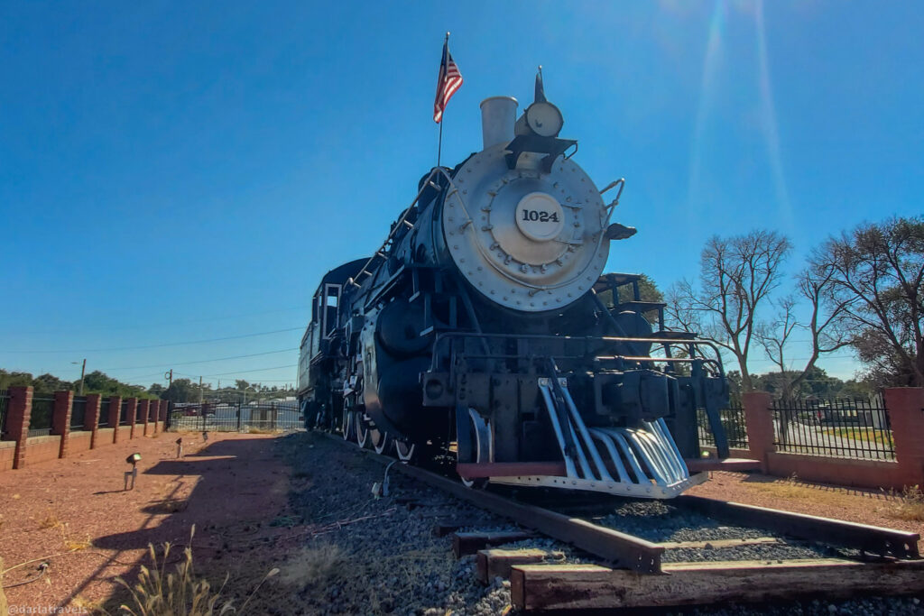 Restored AT&SF steam locomotive #1024 with American flag display in La Junta, Colorado rail park.