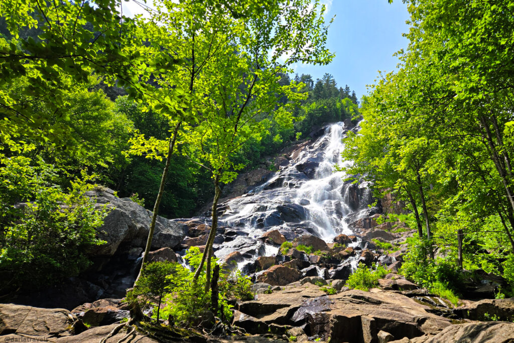 Forested view of Chute Delaney with rocky cascade and pools along hiking trail in Vallée Bras-du-Nord