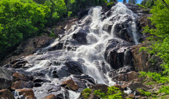 Waterfall at Chute Delaney flowing over rocks, surrounded by forest in Vallée Bras-du-Nord hiking area