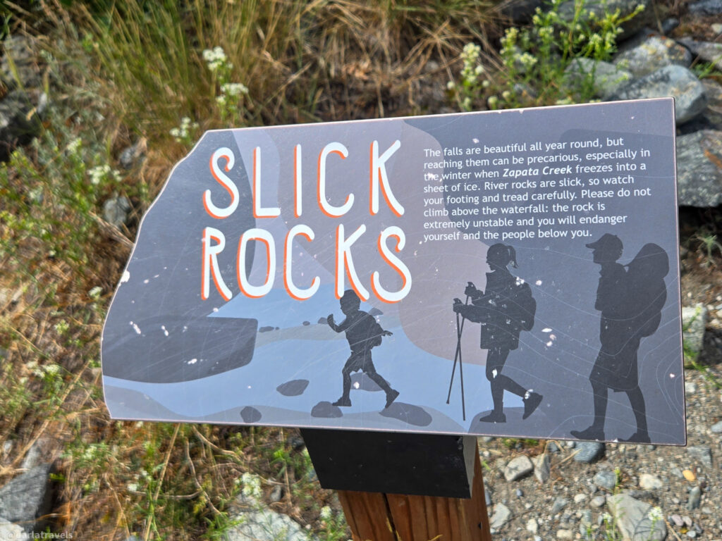Outdoor safety sign warning of slick rocks and icy conditions near Zapata Falls trail in the San Luis Valley, Colorado