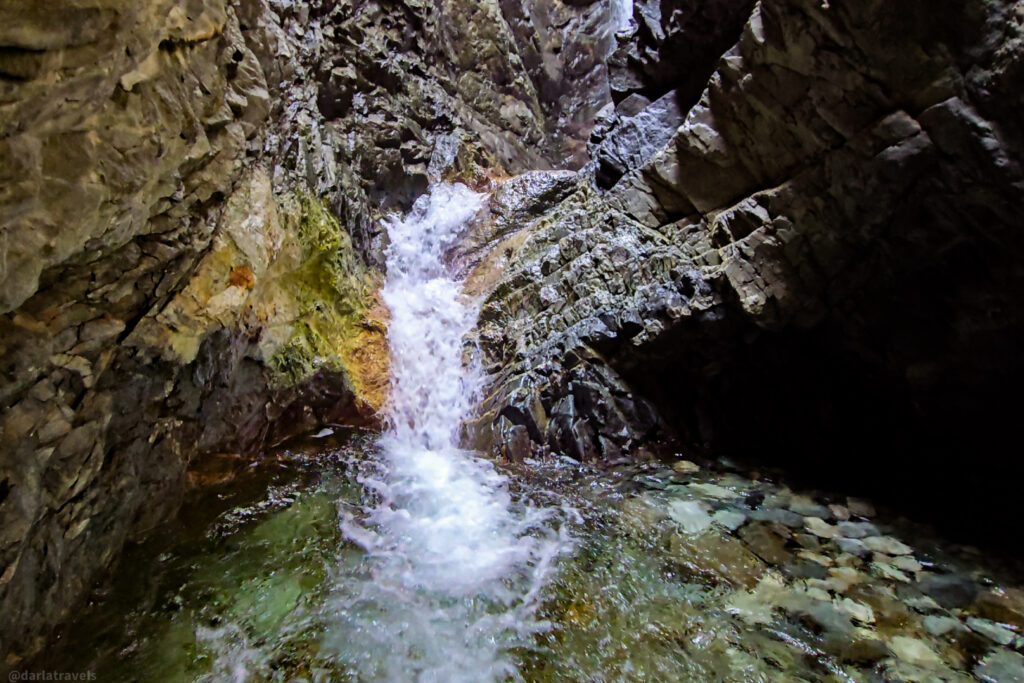 Small waterfall flowing into shallow pool within rocky gorge at Zapata Falls near Alamosa, Colorado