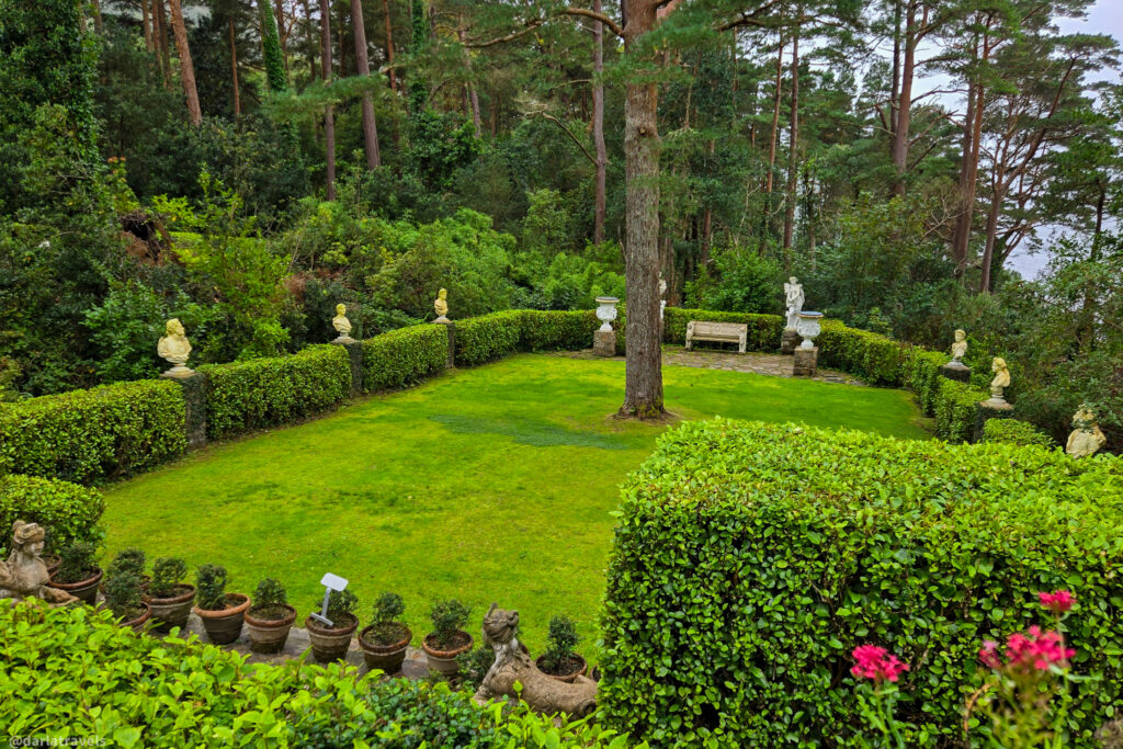 Manicured garden near Glenveagh Castle in Donegal with bust sculptures, hedges, and potted plants