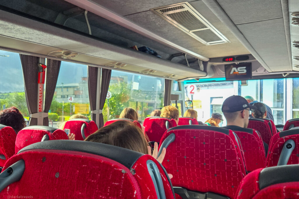 Coach bus interior with red seats and passengers boarding at Letterkenny Coach Station
