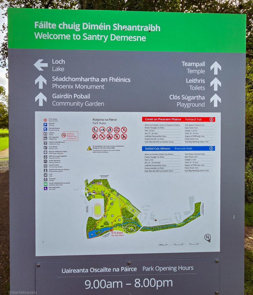Informational sign at Santry Demesne entrance with bilingual map, trail details, and park rules