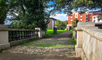 Cobblestone path through stone bridge leading to modern buildings in Santry, near Dublin Airport