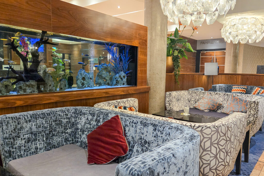 Stylish hotel lounge near Dublin Airport with built-in aquarium, chandeliers, and plush seating