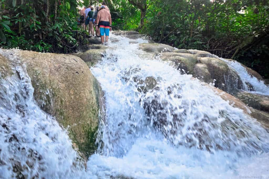 Visitors ascending the flowing rock steps of Dunn’s River Falls during the guided climb.