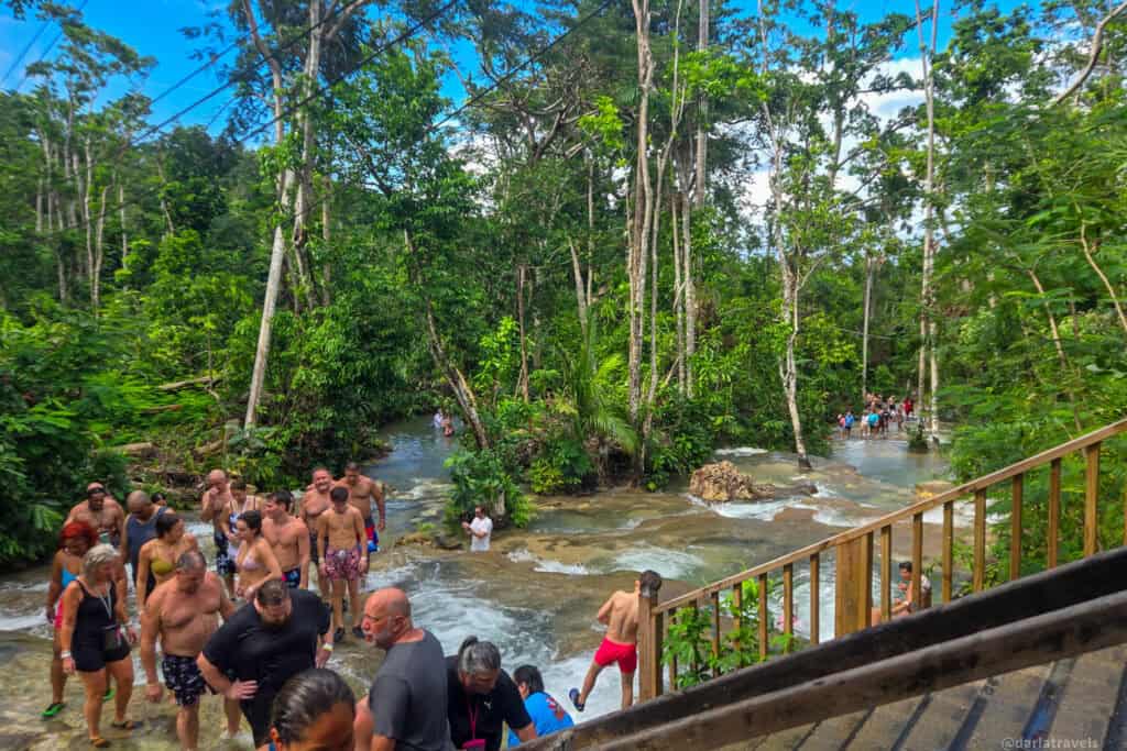 Visitors walking through shallow cascades near Dunn’s River Falls on a guided water trek.