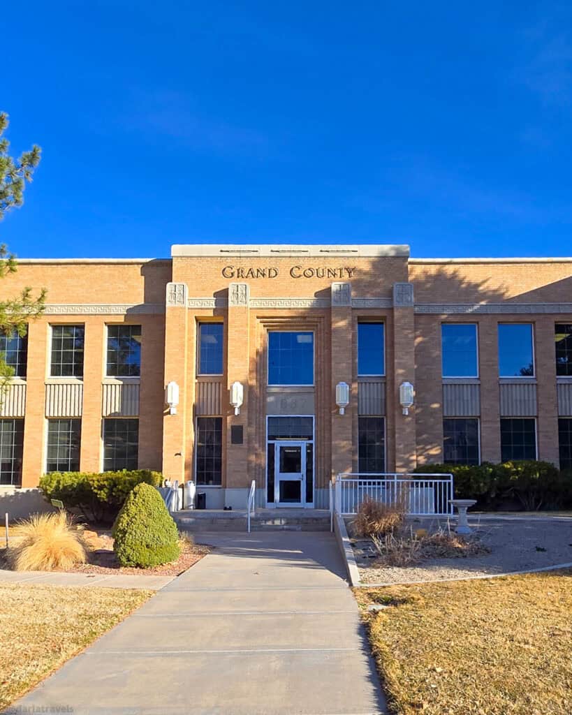 Art Deco Grand County building with brick façade and 1937 entry seen along a short walk in Moab.