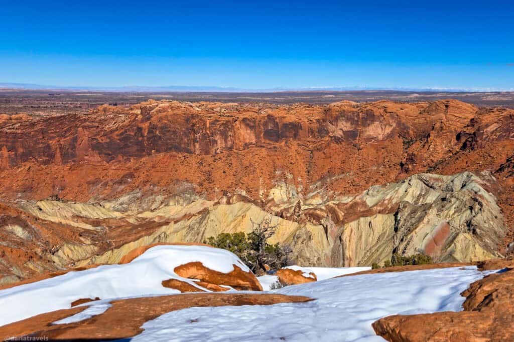 Upheaval Dome’s circular geologic formation in Canyonlands National Park. Striped sandstone ridges with winter snow.
