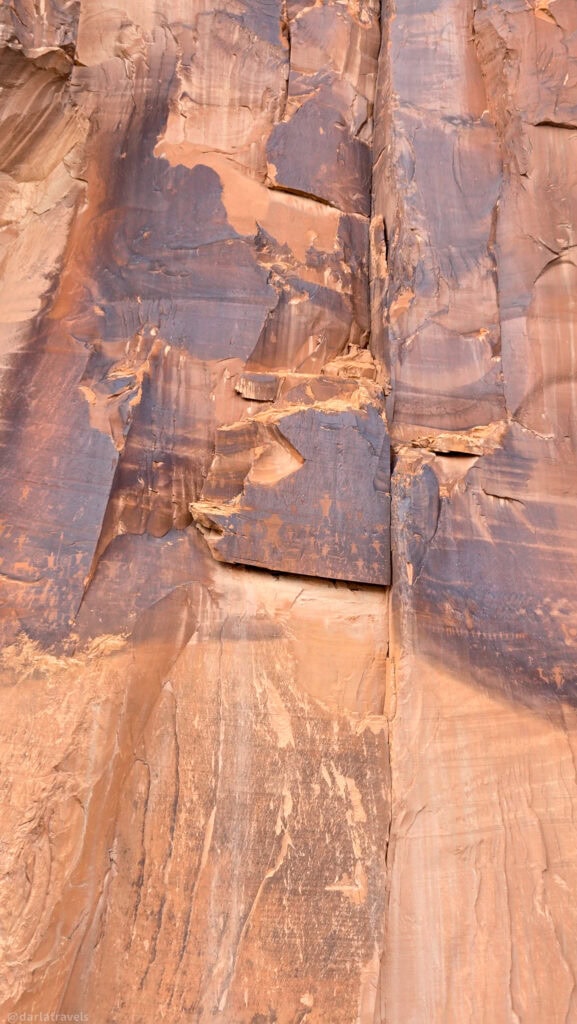 Geometric shapes, figures, and handprints carved into a weathered cliff at the Highway 279 Rock Art Site.