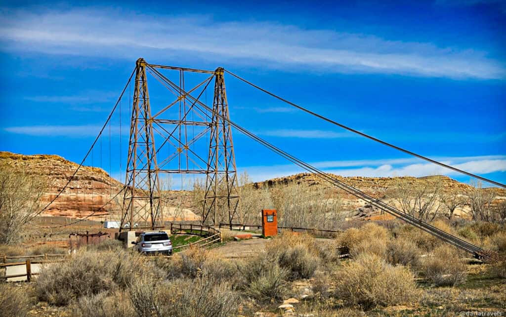 Steel cable‑tower structure rising above desert terrain along a quiet backcountry route near Moab. Remains of Dewey Bridge.