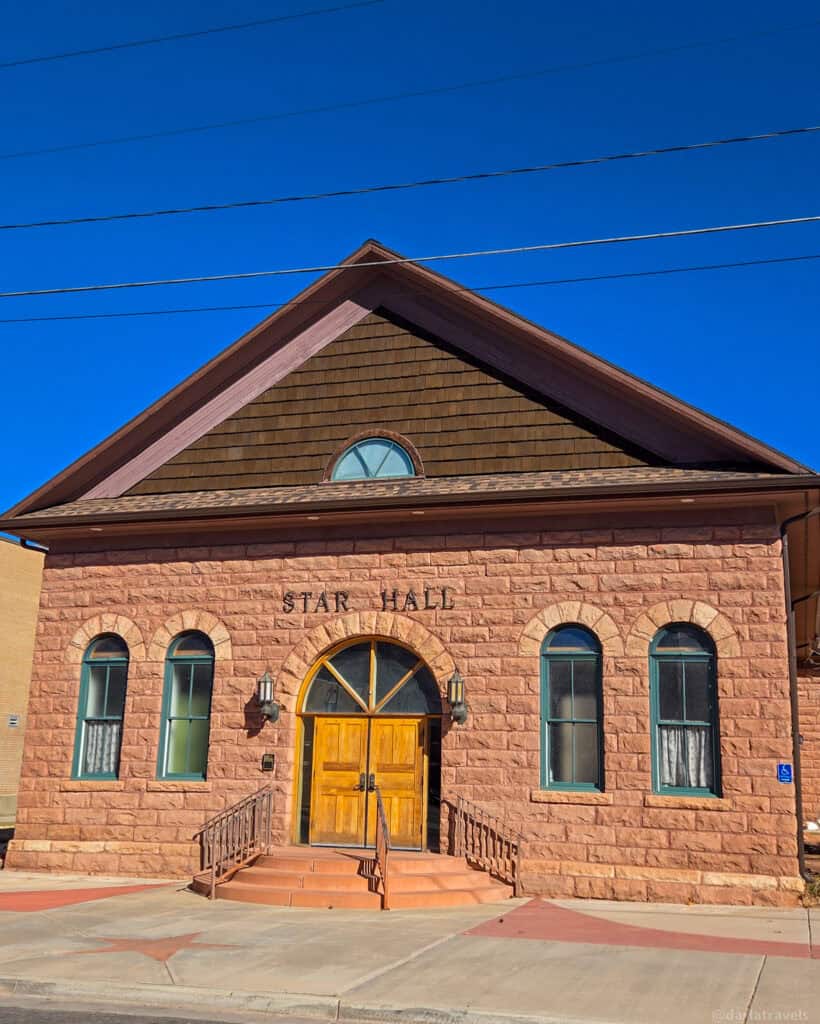 Stone‑built Star Hall with arched doorway and windows along a short walk in downtown Moab.