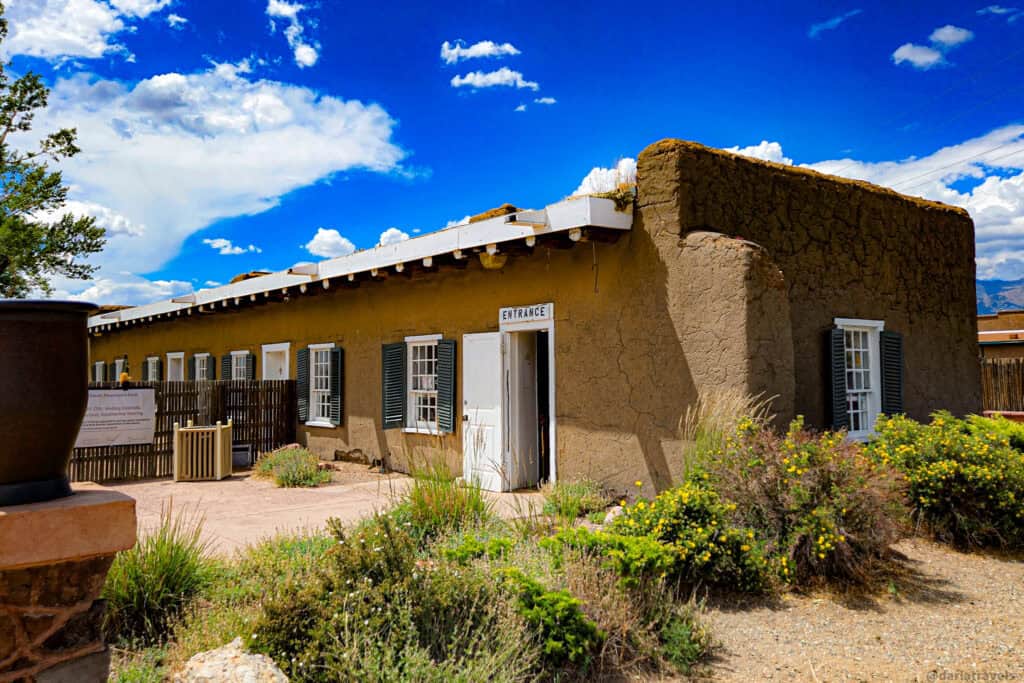 Adobe building with white-trimmed entrance door and green shutters at a historic site in the San Luis Valley Colorado. Fort Garland Museum & Cultural Center