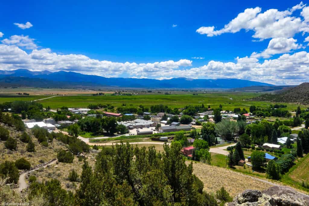 Aerial view of San Luis Colorado town with green valley and mountain range under a blue cloudy sky