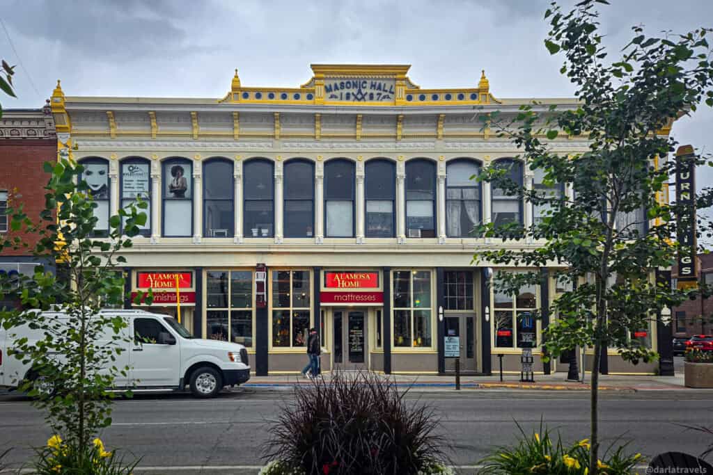 Historic yellow Masonic Hall building from 1874 in downtown Alamosa, Colorado with Victorian facade