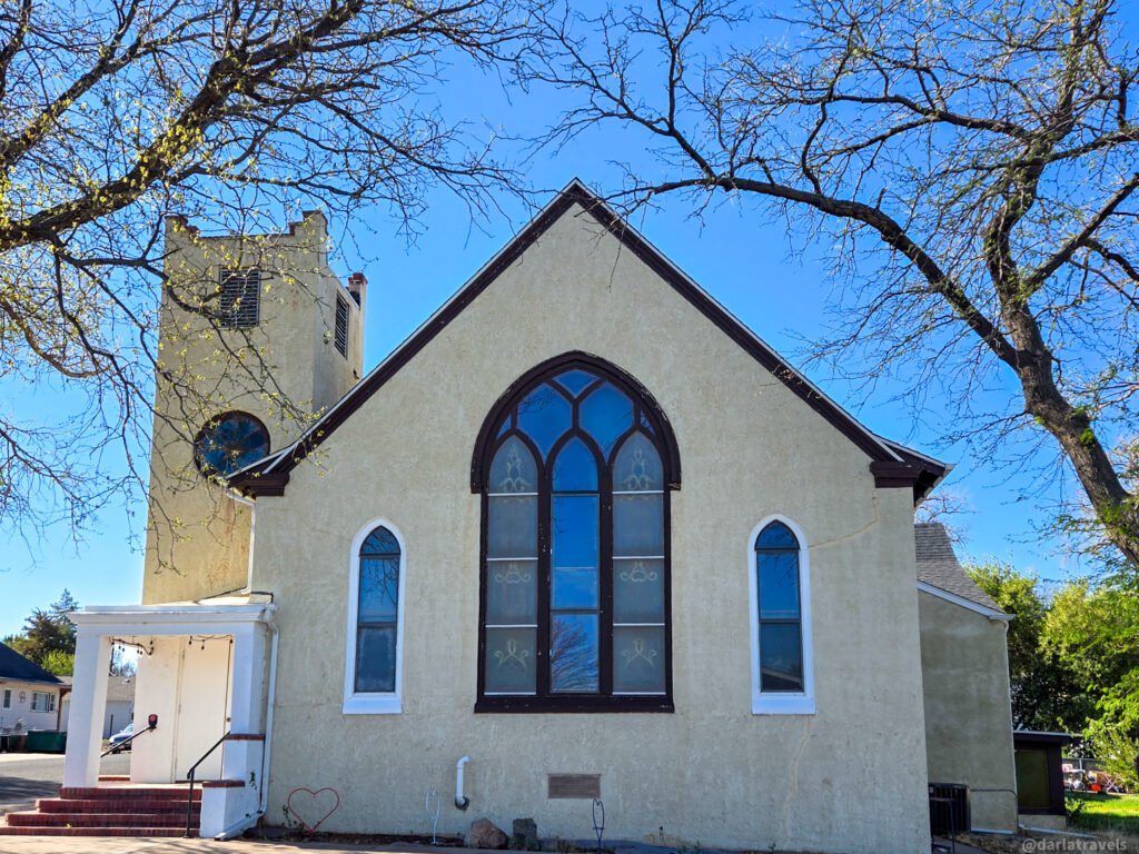 Light-colored church with a tall tower and stained-glass windows in Wray; former First Presbyterian Church