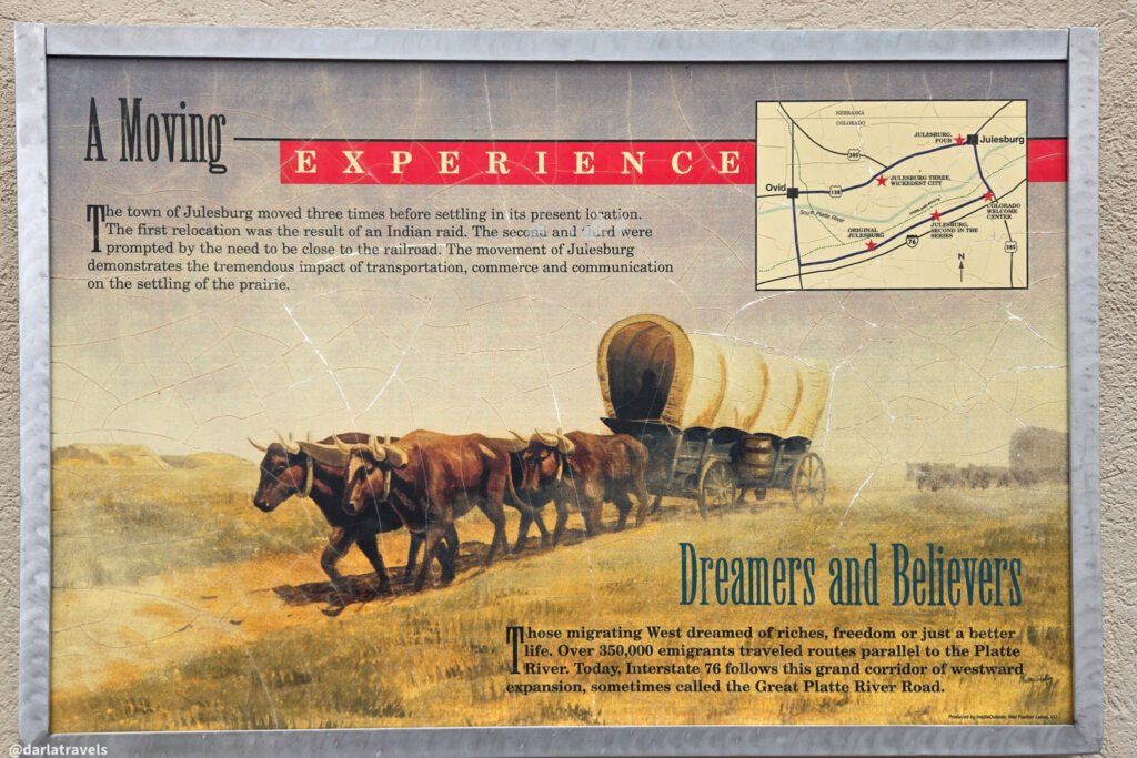 Interpretive panel mapping Julesburg's four locations, with an illustration of an ox-drawn covered wagon.