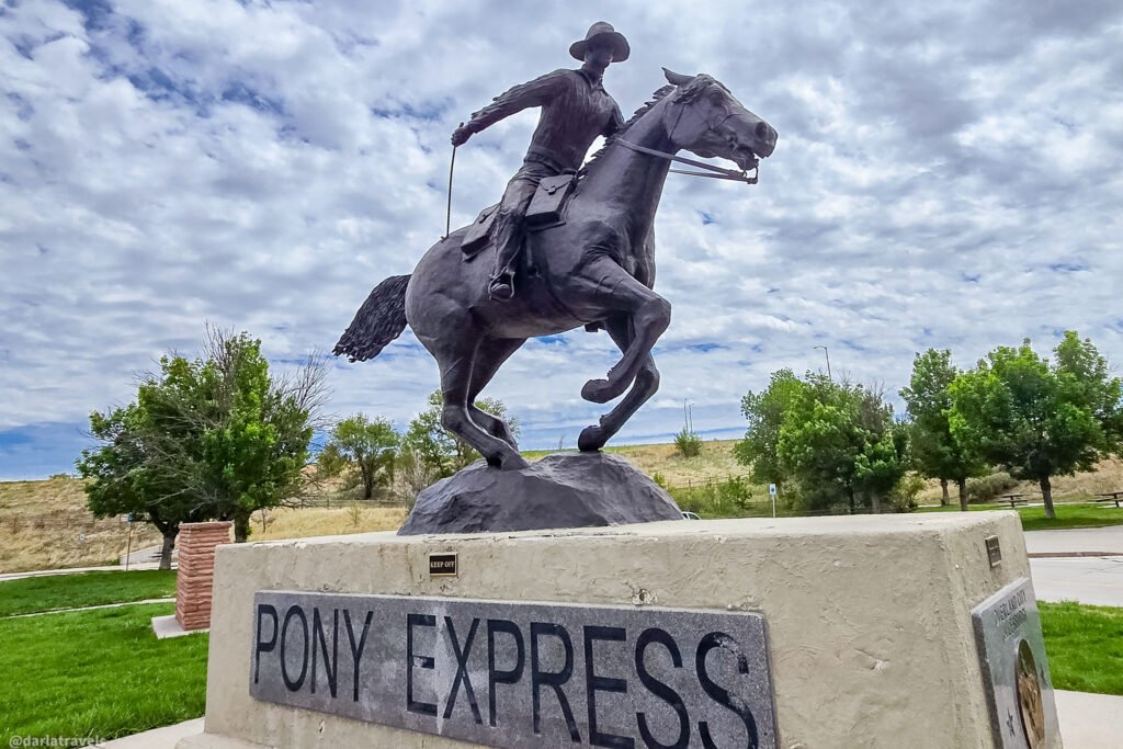 Pony Express rider statue in Julesburg, with the horse’s front legs raised above a labeled pedestal.