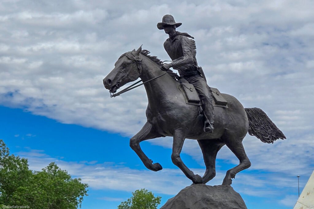 Statue of a rider leaning forward on a galloping horse near Julesburg's Colorado Welcome Center.