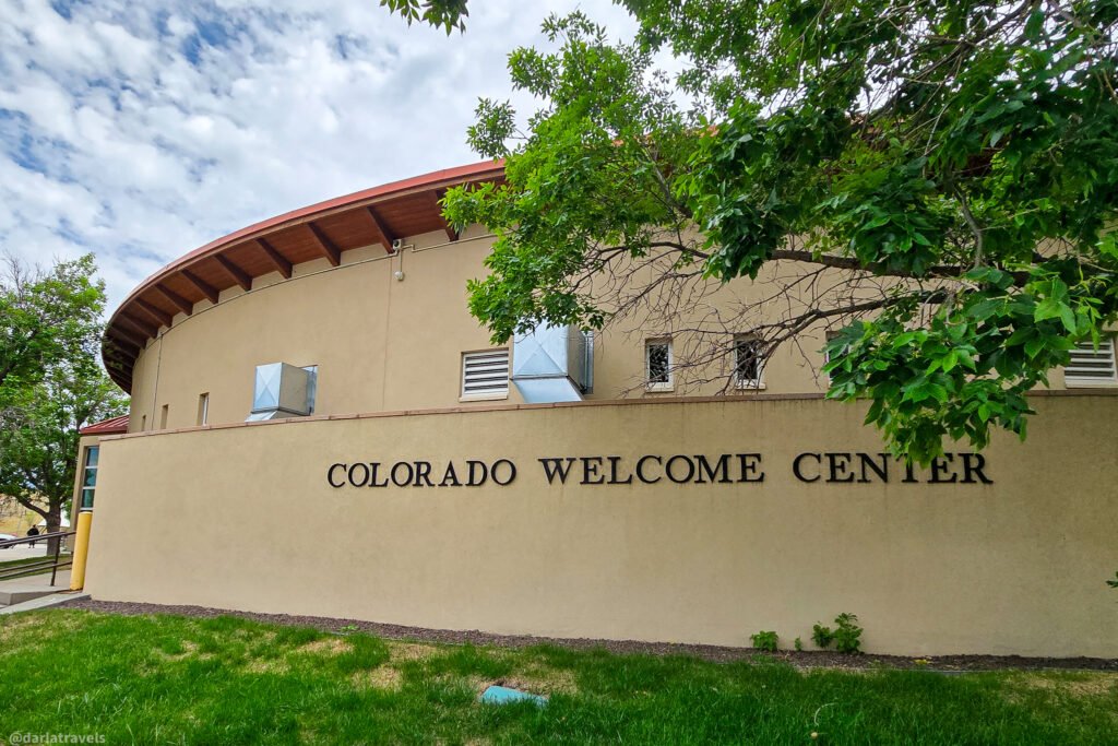 Colorado Welcome Center in Julesburg, with a curved roof and its name on a tan exterior wall.
