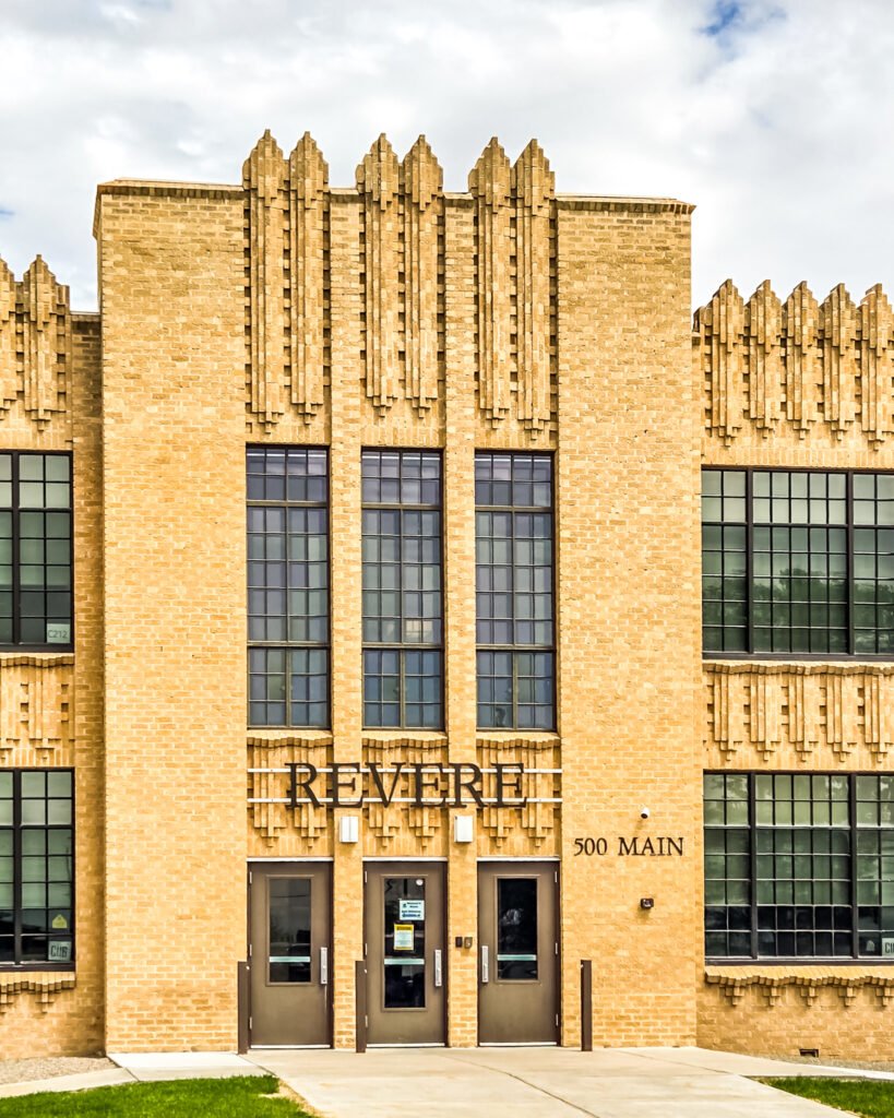 Yellow-brick building with decorative vertical brickwork, tall windows, and signs reading “Revere” and “500 Main.”