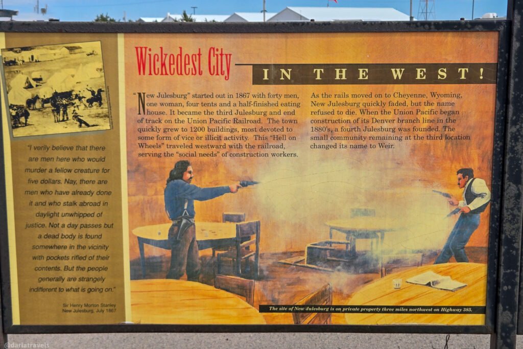 Julesburg's 'Wickedest City in the West!' interpretive panel, illustrated with a saloon gunfight.