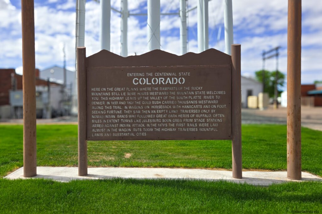 Historical marker beneath Julesburg's water tower describing travel through the South Platte River valley.