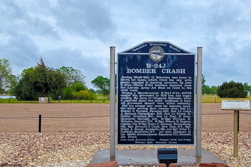 B-24J Bomber Crash historical marker at Chappell Pony Express Park, with the lake and trees behind it.