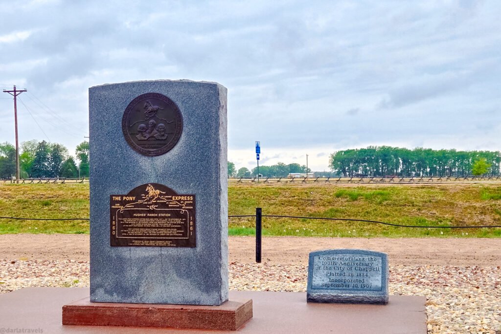 Hughes’ Ranch Pony Express monument with bronze plaques beside a smaller Chappell anniversary marker.