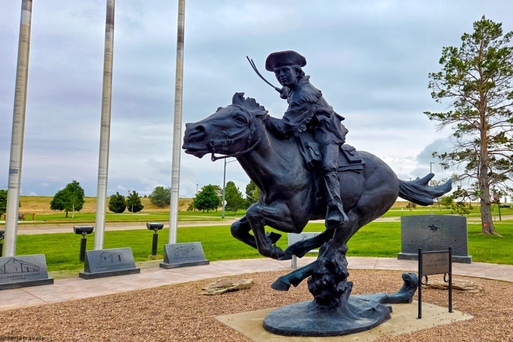 Pony Express rider sculpture on a galloping horse, surrounded by station markers in Sidney, Nebraska.