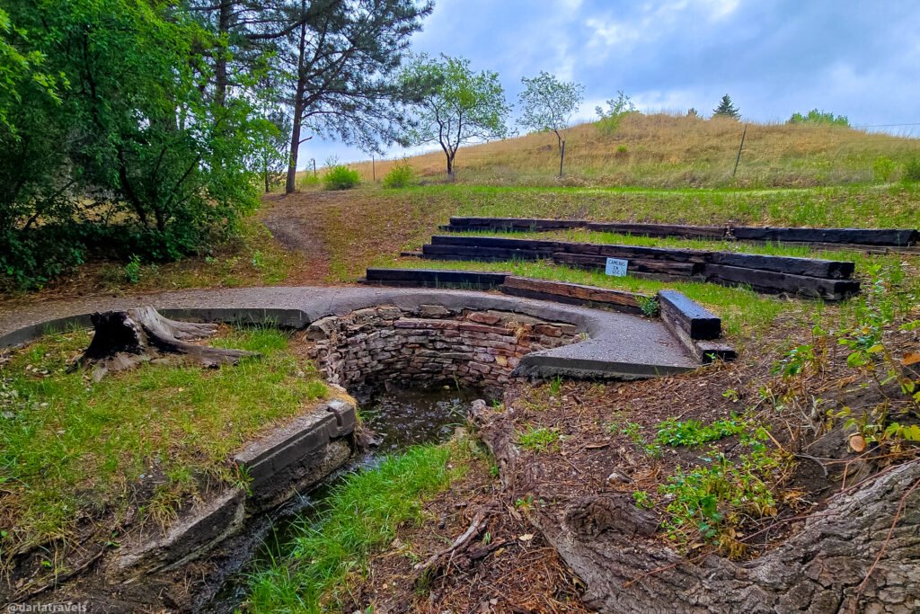 The Big Spring in Big Springs, Nebraska, flowing from a curved stone-lined basin into a narrow channel.